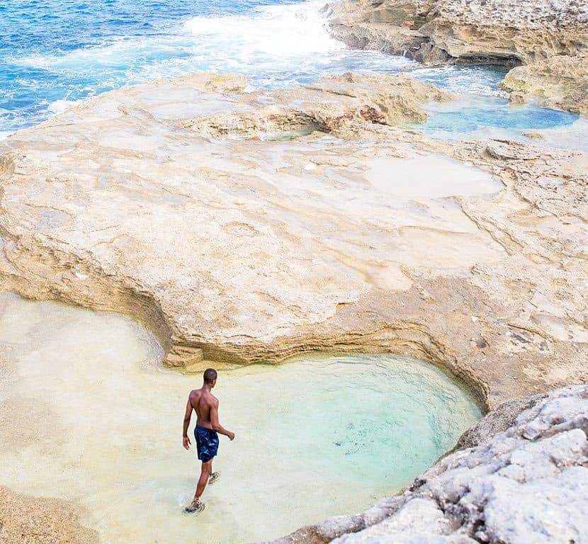 A swimmer in the rock tide pools of the Queen's Baths, Eleuthera