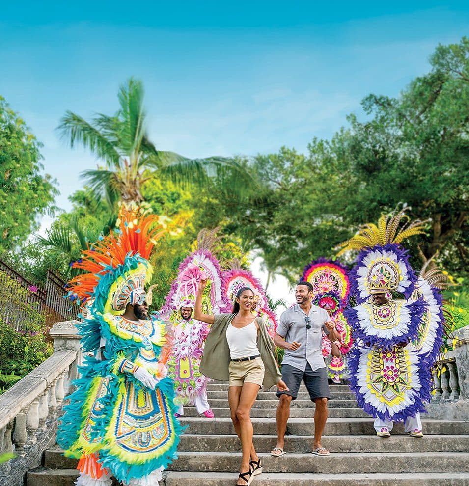 Junkanoo performers in full costume on a stairway in Nassau