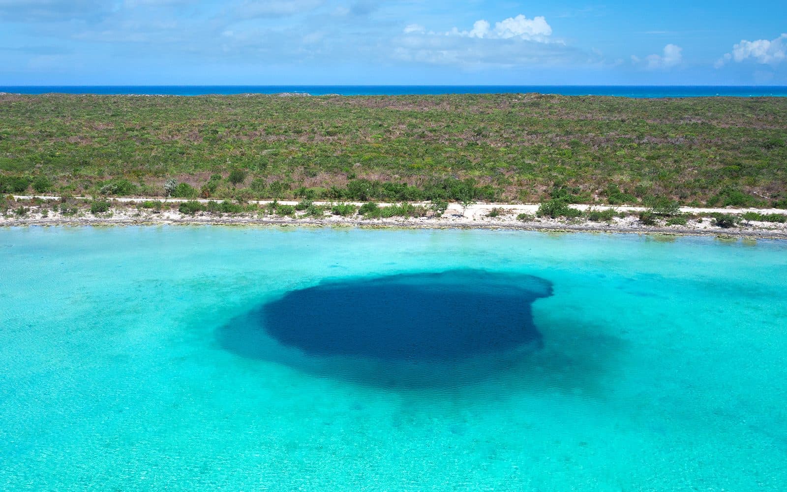 Aerial view of an ocean blue hole in the shallow banks of The Bahamas