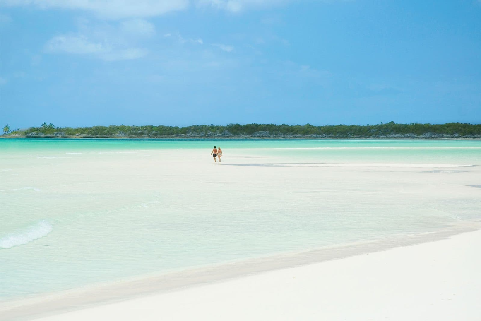 A walker on a long sandbar in shallow water off Ragged Island